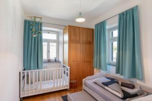 a nursery with green curtains and a crib at Eifel with Family in Thür