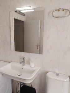 a bathroom with a sink and a mirror and a toilet at Casa Rural Casa Juli in Arguedas +13 photos