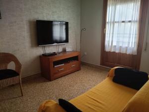a living room with a flat screen tv and a couch at Casa Rural Casa Juli in Arguedas
