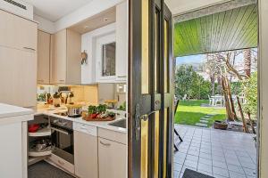 a kitchen with a door open to a garden at Casa Viola Losone for 8 - Happy Rentals in Losone