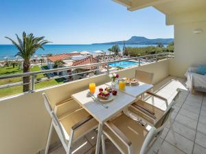 a table and chairs on a balcony with a view of the ocean at GK Beach Hotel in Kalyves