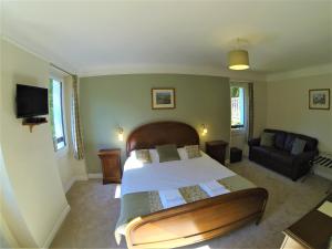 a bedroom with a large bed and a couch at Auberge de la Sagne in Cabrerets