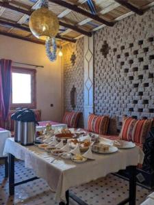 a table with plates of food on it in a room at Moon Dunes camp in Adrouine