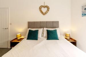 a bedroom with a large white bed with two lamps at Seascape - Fantastic Location with Sea Views! in Scarborough