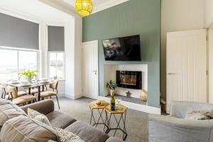 a living room with a couch and a table at Seascape - Fantastic Location with Sea Views! in Scarborough