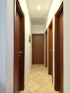 a hallway with brown doors and a tile floor at ilioni house in Skopelos Town +23 photos