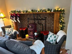 a living room with a fireplace with christmas decorations at Chambers Cottage in Drumellihy