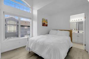a white bedroom with a bed and a window at Guest House in Calgary Downtown in Calgary