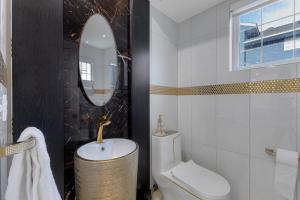 a bathroom with a sink and a toilet and a mirror at Guest House in Calgary Downtown in Calgary +25 photos