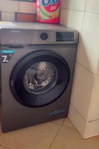 a washing machine with its door open in a room at Malaika Villas in Kampala
