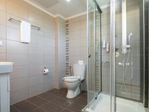 a bathroom with a toilet and a glass shower at GK Beach Hotel in Kalyves +31 photos
