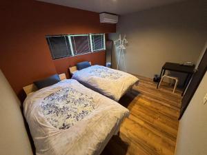 a bedroom with two beds and a desk in it at コハクサカイミナト in Sakaiminato