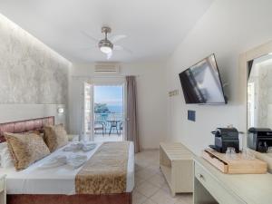 a bedroom with a bed and a tv on the wall at Pension Votsi in Votsi