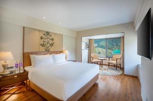 a hotel room with a large bed and a table at Radisson Hotel Sonamarg in Sonāmarg