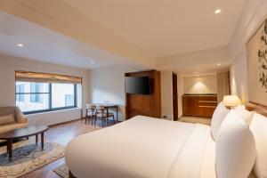 a bedroom with a large white bed and a living room at Radisson Hotel Sonamarg in Sonāmarg