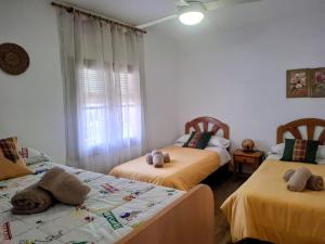 a bedroom with two beds with stuffed animals on them at Villa Marovi Bonalba in Alicante +18 photos