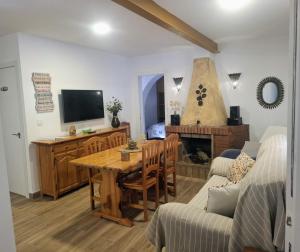 a living room with a wooden table and a tv at Villa Marovi Bonalba in Alicante