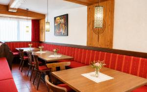 a restaurant with wooden tables and red booths at first mountain Hotel Zillertal in Aschau