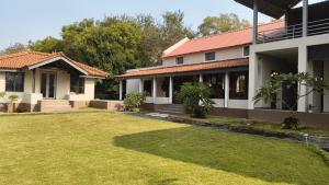 a house with a lawn in front of it at Moner Pukur in Bolpur
