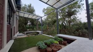 a patio with potted plants and a bench at Moner Pukur in Bolpur