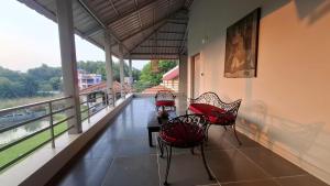 two chairs and a table on a balcony with a view at Moner Pukur in Bolpur +4 photos