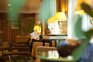a woman reading a newspaper in a hotel room at Perugia Plaza Hotel in Perugia +57 photos