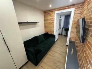 a living room with a couch and a brick wall at Historical Apartments by Stepan Fedak in Lviv