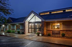 a house with a parking lot in front of it at AmericInn by Wyndham Red Wing in Red Wing