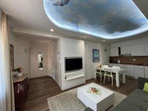 ein Wohnzimmer mit einer Couch und einem Fernseher an der Decke in der Unterkunft Apartments Villa BEAUTY PORTOROŽ in Portorož