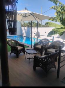 a group of chairs and an umbrella next to a pool at Recanto Guarujá Moc in Montes Claros