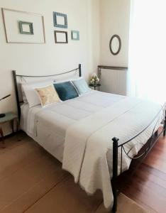 a bedroom with a large bed with white sheets and pillows at La casetta in Candelo