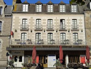 a building with red umbrellas in front of it at Hôtel Marguerite in Dinan