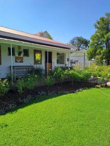 a white house with a lawn in front of it at Meerlin Guest House in Queenstown