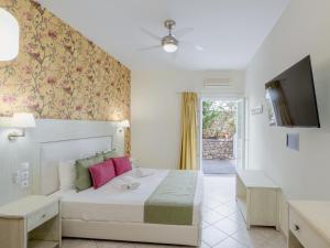 a bedroom with a bed and a tv in it at Pension Votsi in Votsi