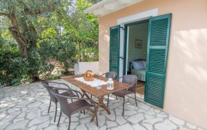 a wooden table and chairs on a patio at Eleni's Apartments in Barbati