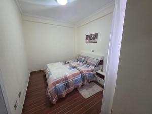 a small bedroom with a bed and a night stand at Goldsip lounge in Dirē Kʼalu
