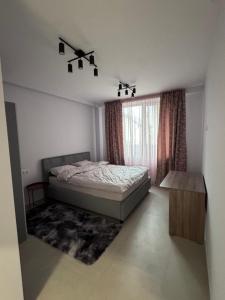 a bedroom with a bed and a table and a window at Apart Hotel Balti 2 in Bălţi