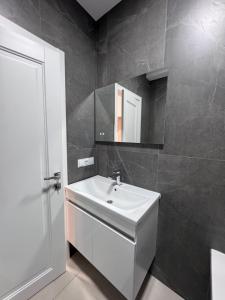 a bathroom with a white sink and a mirror at Apart Hotel Balti 2 in Bălţi