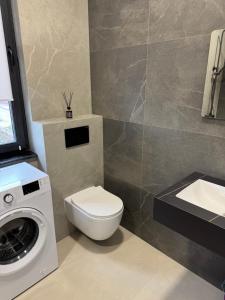 a bathroom with a toilet and a washing machine at Apart Hotel Balti 2 in Bălţi