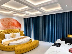 a bedroom with a large yellow bed with a yellow couch at Love Luxury Hotel Bà Điểm in Ho Chi Minh City +49 photos