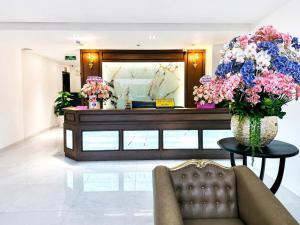 a room with a table with a vase of flowers at Love Luxury Hotel Bà Điểm in Ho Chi Minh City