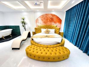 a bedroom with a large yellow bed and a bath tub at Love Luxury Hotel Bà Điểm in Ho Chi Minh City