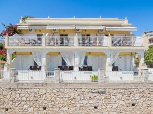a large white house on a stone wall at Pension Votsi in Votsi