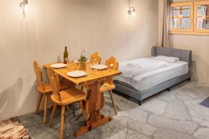 a dining room with a table and chairs and a bed at Studio chaleureux au coeur d'un chalet alpin in Zinal