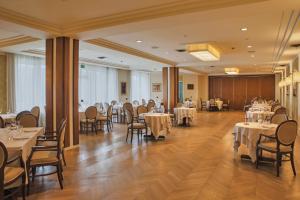 a dining room with tables and chairs in a room at Perugia Plaza Hotel in Perugia