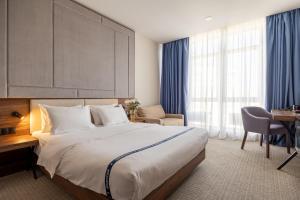 a hotel room with a large bed and a desk at Ribas Rooms Odesa in Odesa