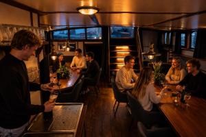 a group of people sitting at a bar in a restaurant at Zeilschip de Alliantie Kampen in Kampen