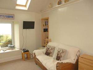 a living room with a couch with two deer pillows at 1 Bed in Isle Of Arran oc-ca344 in Kilmory
