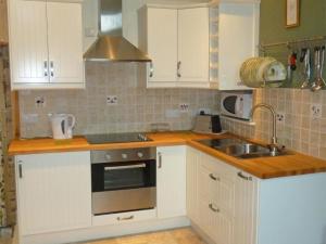 a kitchen with white cabinets and a sink at 1 Bed in Isle Of Arran oc-ca344 in Kilmory +6 photos