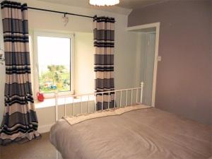 a bedroom with a bed with curtains and a window at 1 Bed in Isle Of Arran oc-ca344 in Kilmory